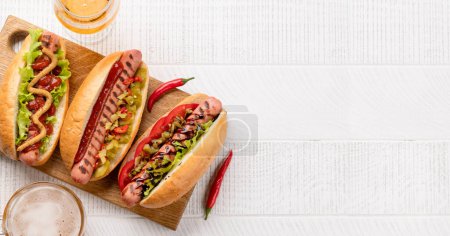Foto de Various hot dog and beer. Homemade hotdogs on cutting board. Flat lay with copy space - Imagen libre de derechos