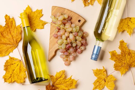 Téléchargez les photos : Bouteilles de vin blanc, raisins et feuilles d'automne. Pose plate - en image libre de droit