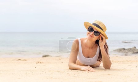 Téléchargez les photos : Femme couchée sur la plage de la mer profiter et se détendre en été - en image libre de droit