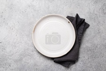 Foto de Placa vacía y toalla en la mesa de la cocina de piedra. Piso con espacio de copia - Imagen libre de derechos