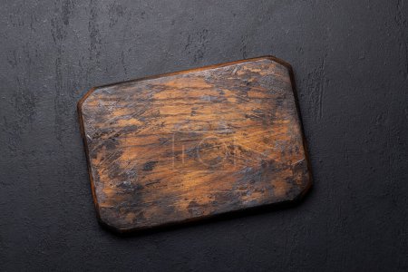 Téléchargez les photos : Wooden cutting board on stone kitchen table. Flat lay with copy space - en image libre de droit