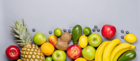 Téléchargez les photos : Fruits sains nourriture sur fond gris. Pose plate avec espace de copie - en image libre de droit