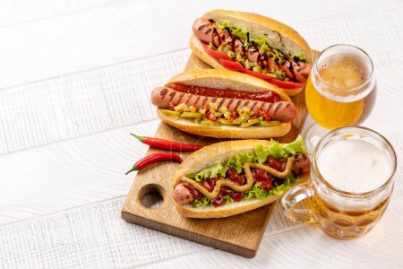 Téléchargez les photos : Divers hot dog et bière. Hotdogs faits maison sur planche à découper. Avec espace de copie - en image libre de droit
