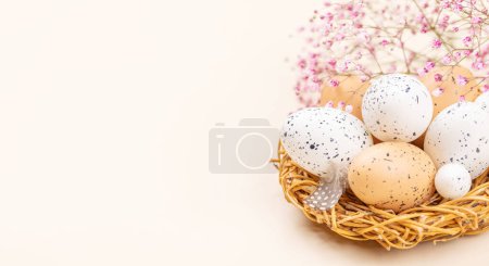 Téléchargez les photos : Oeufs et fleurs de Pâques sur fond beige avec espace pour vos salutations - en image libre de droit