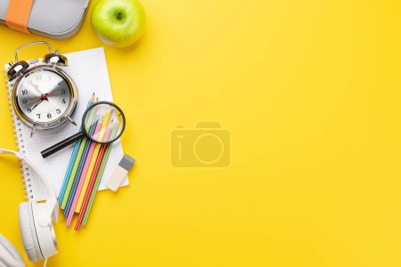 Foto de Material escolar y papelería sobre fondo amarillo. Piso con espacio en blanco - Imagen libre de derechos