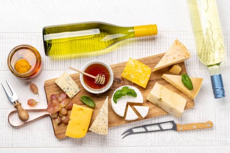 Foto de Various cheese on board and white wine. Flat lay - Imagen libre de derechos