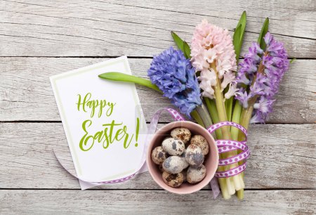 Foto de Tarjeta de felicitación de Pascua con huevos de Pascua y ramo de flores de jacinto. Vista superior plano laico - Imagen libre de derechos