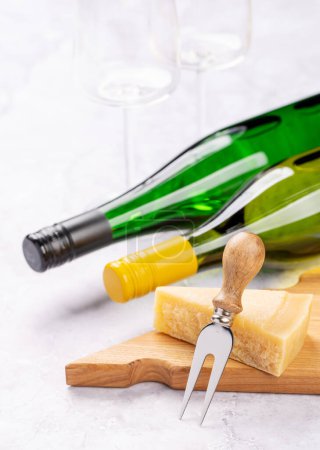 Photo pour Divers fromages à bord et bouteilles de vin blanc. Avec espace de copie - image libre de droit