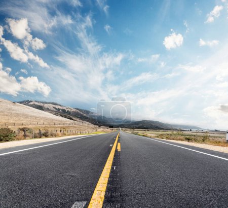 Téléchargez les photos : Route asphaltée et paysage champêtre avec ciel ensoleillé. California State Route One - en image libre de droit