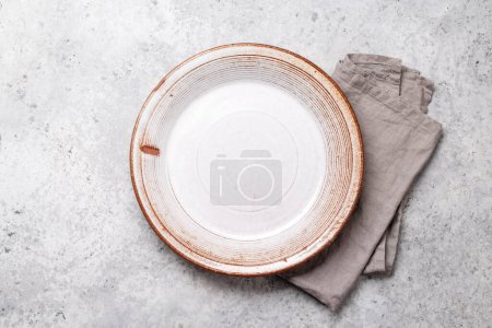 Photo for Empty plate and towel on stone kitchen table. Flat lay with copy space - Royalty Free Image