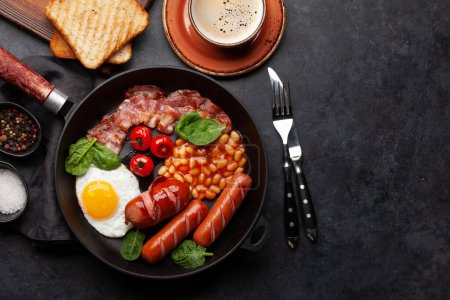 Foto de Desayuno inglés con huevos fritos, frijoles, tocino y salchichas. Vista superior plano con espacio de copia - Imagen libre de derechos