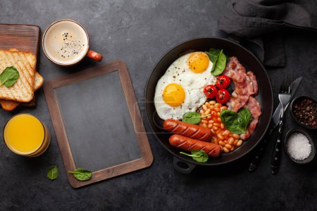Photo for English breakfast with fried eggs, beans, bacon and sausages. Top view flat lay with copy space - Royalty Free Image