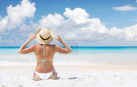 Photo for Woman sitting on the sea beach enjoying and relaxing in summer - Royalty Free Image