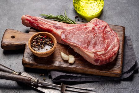 Photo for Raw Tomahawk beef steak and spices. Ready for grilling - Royalty Free Image