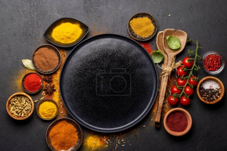 Photo for Empty plate and various spices on stone table. Frame with copy space for your menu or recipe - Royalty Free Image