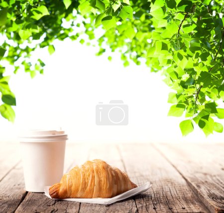 Téléchargez les photos : Tasse à café et croissant sur table en bois. Jardin extérieur - en image libre de droit