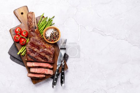 Photo for Medium rare grilled Tomahawk beef steak with asparagus. Flat lay with copy space - Royalty Free Image