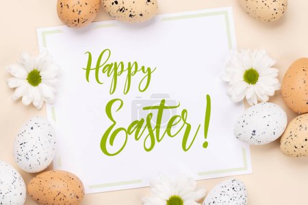 Foto de Huevos de Pascua, flores y tarjeta de felicitación de Pascua sobre un fondo beige. Puesta plana - Imagen libre de derechos