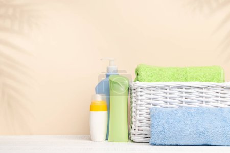 Foto de Artículos para el cuidado del cuerpo y toallas de baño en la mesa con espacio para su producto o texto. Arreglo spa - Imagen libre de derechos