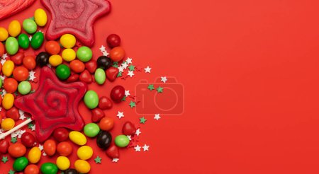 Foto de Various candy sweets on red background and copy space for your text. Flat lay - Imagen libre de derechos