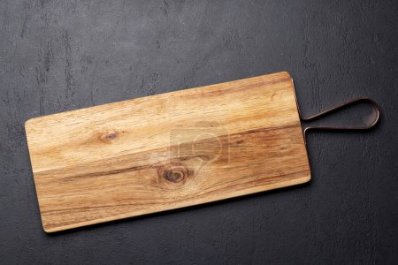 Téléchargez les photos : Planche à découper en bois sur table de cuisine en pierre. Pose plate avec espace de copie - en image libre de droit