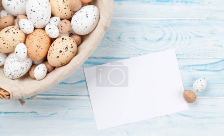 Téléchargez les photos : Carte de vœux de Pâques avec œufs de Pâques dans le panier. Vue du dessus plat avec espace de copie - en image libre de droit