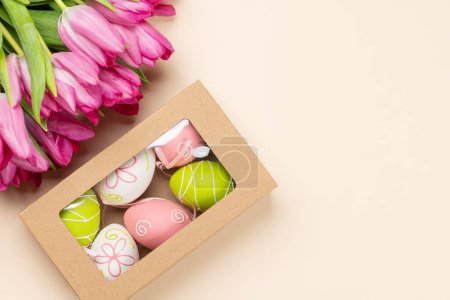 Téléchargez les photos : Bouquet de fleurs de tulipe rose, boîte cadeau avec des œufs de Pâques. Pose plate avec espace de copie - en image libre de droit