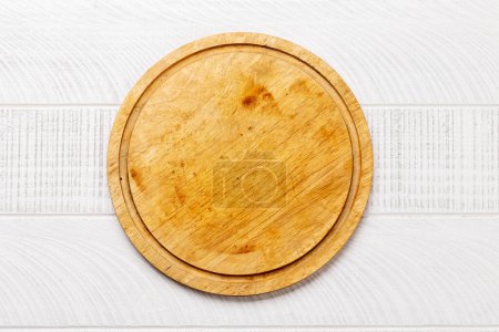 Photo for Wooden cutting board on white kitchen table. Flat lay with copy space - Royalty Free Image