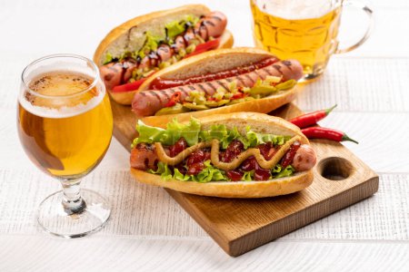 Foto de Various hot dog and beer. Homemade hotdogs on cutting board - Imagen libre de derechos