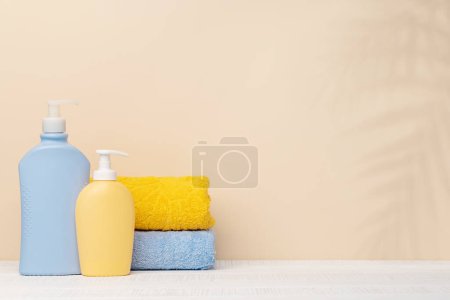 Foto de Artículos para el cuidado del cuerpo y toallas de baño en la mesa con espacio para su producto o texto. Arreglo spa - Imagen libre de derechos