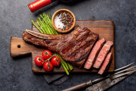 Photo for Medium rare grilled Tomahawk beef steak with asparagus. Flat lay - Royalty Free Image