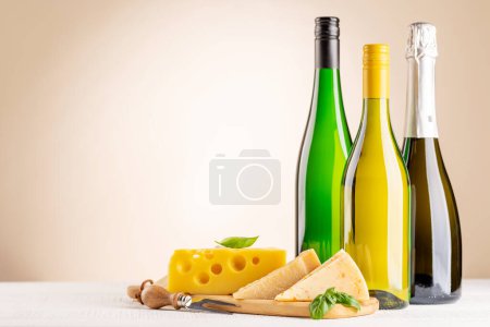 Téléchargez les photos : Various cheese on board and white wine. Over beige background with copy space - en image libre de droit