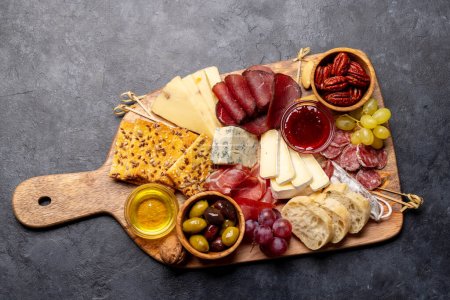 Antipasto board with prosciutto, salami, crackers, cheese, olives and nuts. Flat lay with copy space
