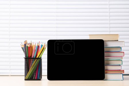 Photo for Tablet with colorful pencils and stack of books. With blank screen for your text or app - Royalty Free Image