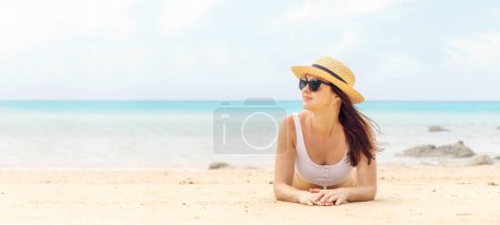 Photo for Woman lying on the sea beach enjoying and relaxing in summer - Royalty Free Image