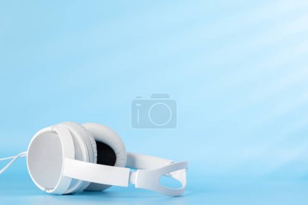 Photo for White headphones on blue background with copy space - Royalty Free Image