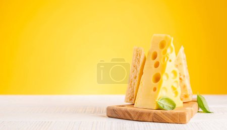 Foto de Various cheese on board. Over yellow background with copy space - Imagen libre de derechos