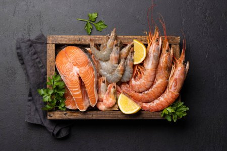 A top view of fresh seafood such as shrimp, langoustines and trout steaks. Flat lay