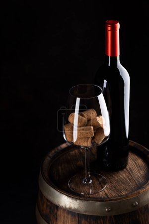 Foto de Botella de vino tinto, barril y copa de vino con corchos. Con espacio en blanco para su texto - Imagen libre de derechos