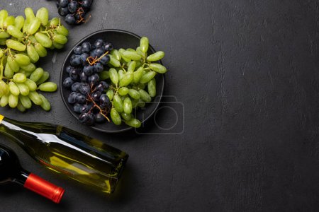 Téléchargez les photos : Une vue de dessus d'une bouteille de vin, raisin, tire-bouchon, et bouchons de vin sur une table, avec beaucoup d'espace ouvert pour le texte. Pose plate - en image libre de droit