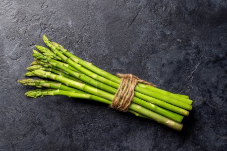 Photo for Bunch of fresh asparagus on stone table. Flat lay with copy space - Royalty Free Image
