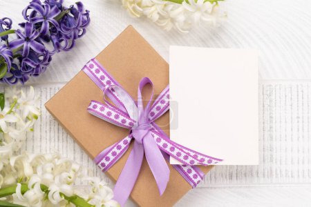 Téléchargez les photos : Belle boîte cadeau avec des fleurs de jacinthe et carte de vœux vierge d'en haut - en image libre de droit