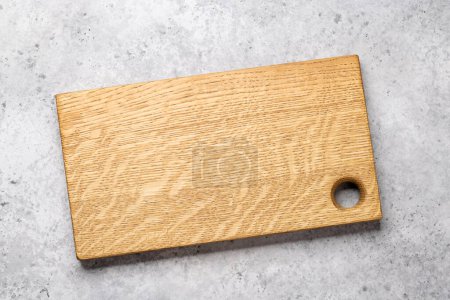 Photo for Wooden cutting board on stone table. Flat lay with copy space - Royalty Free Image
