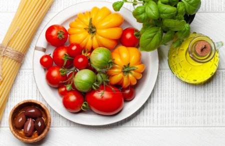 Foto de Varios tomates coloridos del jardín. Verduras frescas y pasta. Vista superior plano con espacio de copia - Imagen libre de derechos
