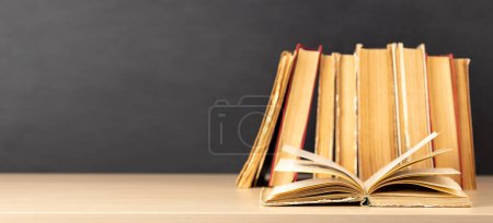 Photo for Old books on a table, with one book open and copy space for your text - Royalty Free Image
