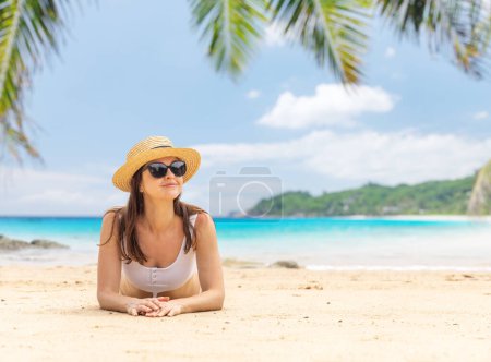Photo for Woman lying on the sea beach enjoying and relaxing in summer - Royalty Free Image