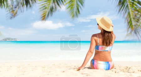 Téléchargez les photos : Femme en bikini sur la plage de la mer tropicale profiter et se détendre en été - en image libre de droit