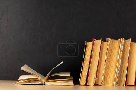 Photo for Old books on a table, with one book open and copy space for your text - Royalty Free Image