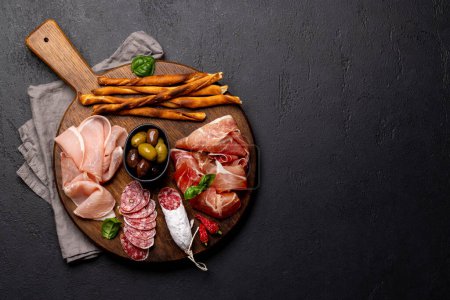 Téléchargez les photos : Antipasto board with various meat and snacks. Flat lay with copy space - en image libre de droit