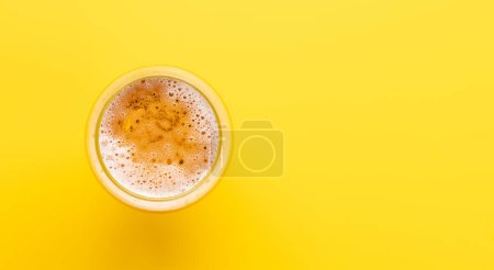 Téléchargez les photos : Une bière froide sur un fond jaune vif avec espace de copie. Pose plate - en image libre de droit